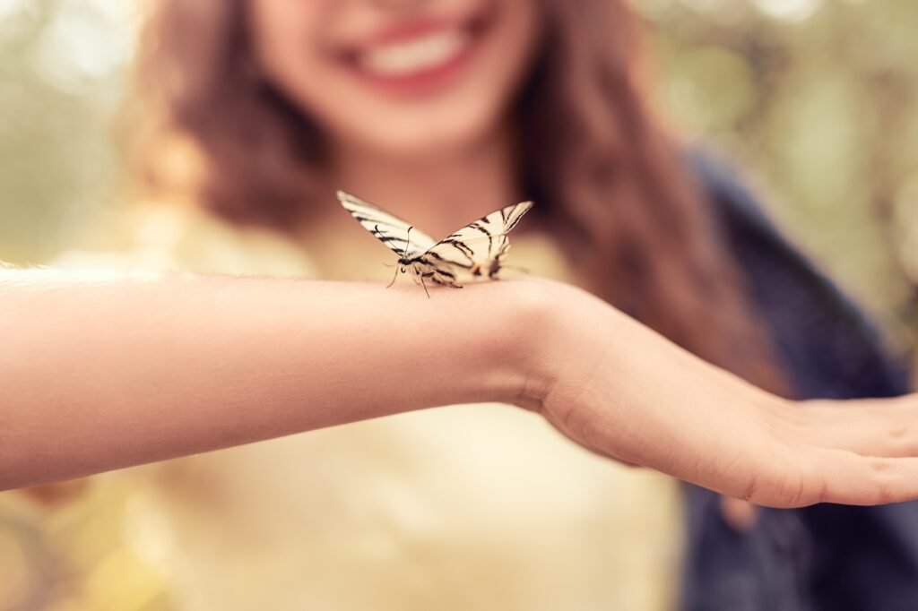 Butterfly sitting on arms of woman